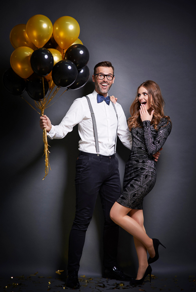 Man embracing and giving bouquet of balloons his surprised girlfriend